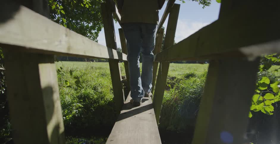 A man walks down a narrow bridge