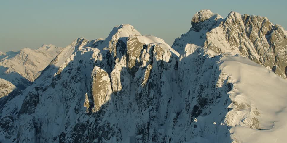 The large mountain range is covered with snow