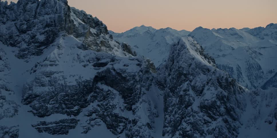 Snow covered mountain ridges at sunset