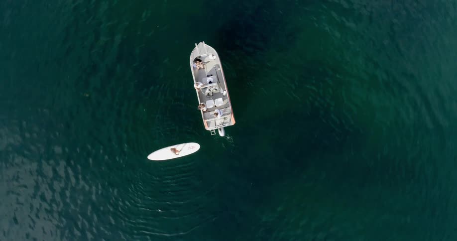 A surfer floats next to a boat