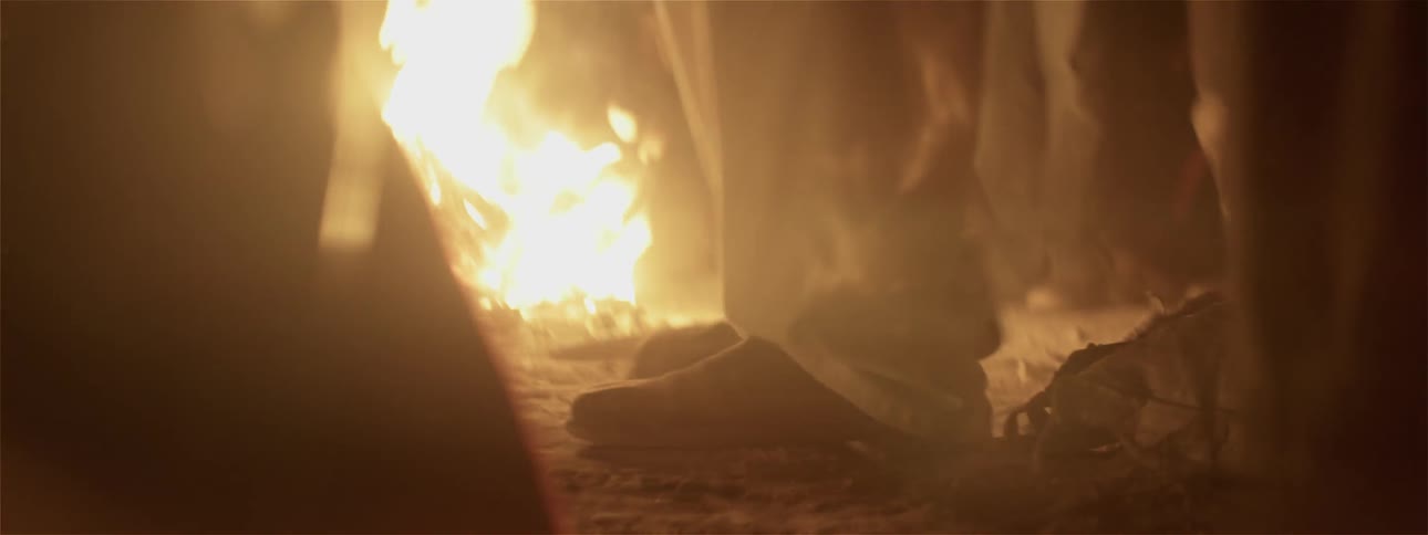 People dance next to a campfire
