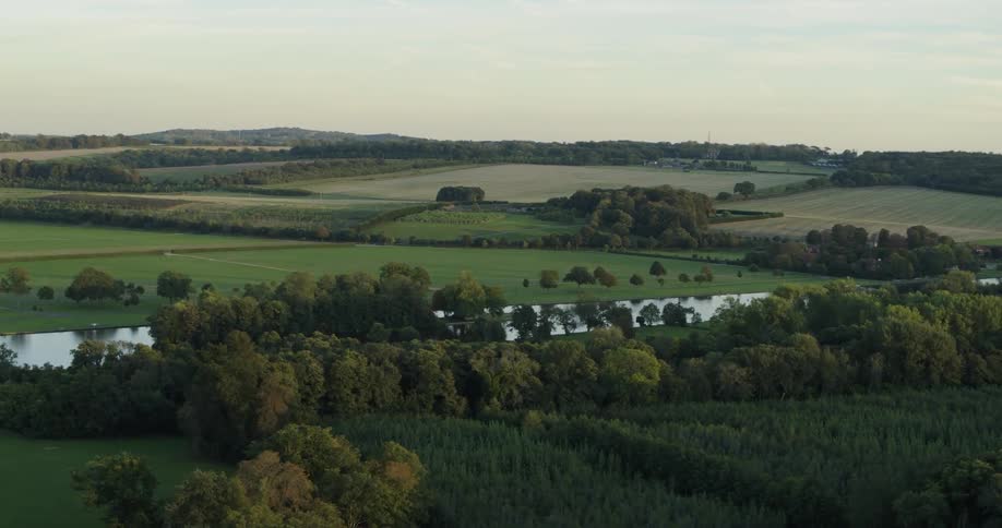 A river flows through a rural landscape at sunset