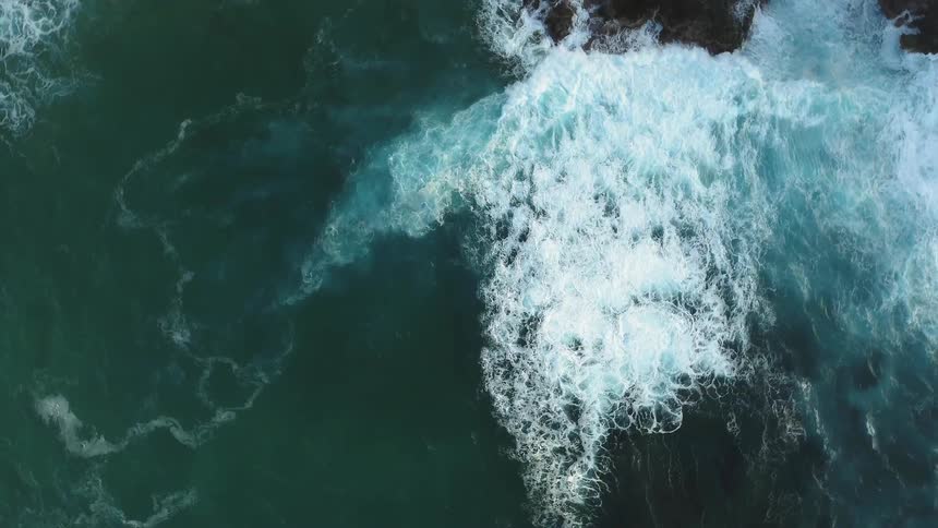 White frothy waves crash into the rocks