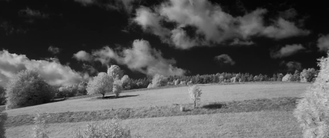Clouds hang above a hilly landscape