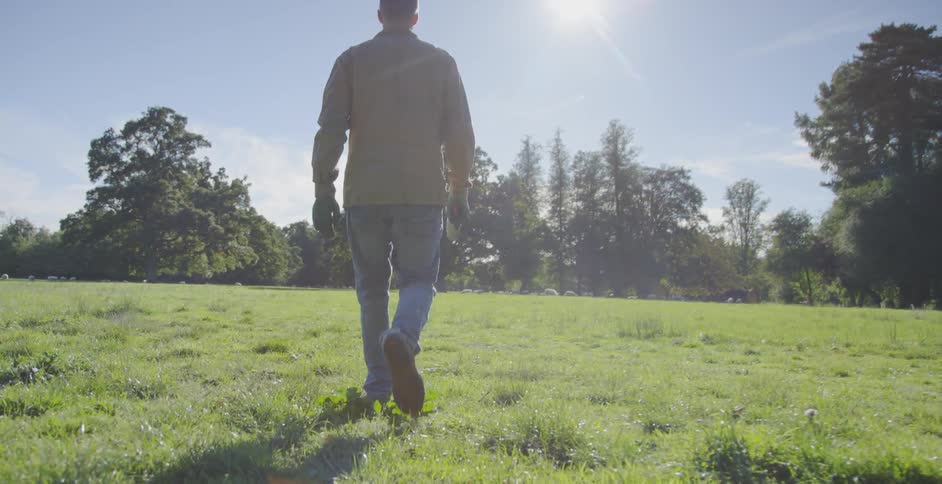 Man walks across a grassy field