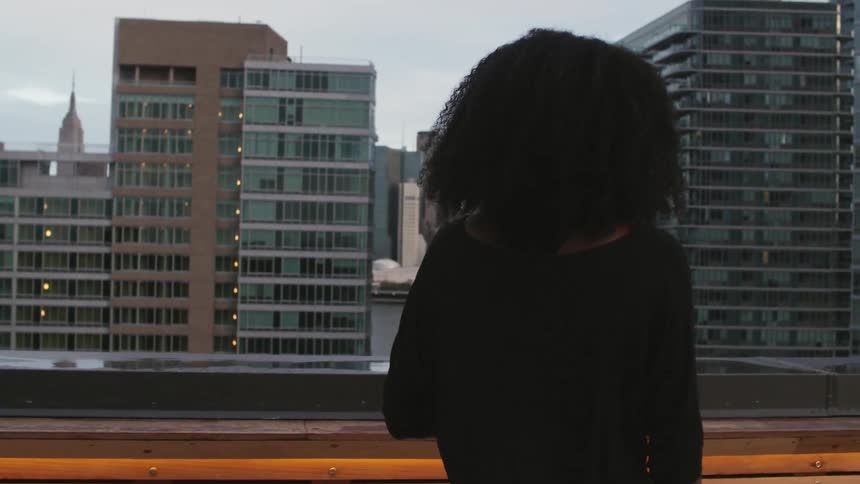 A woman in a black shirt walks on a roof
