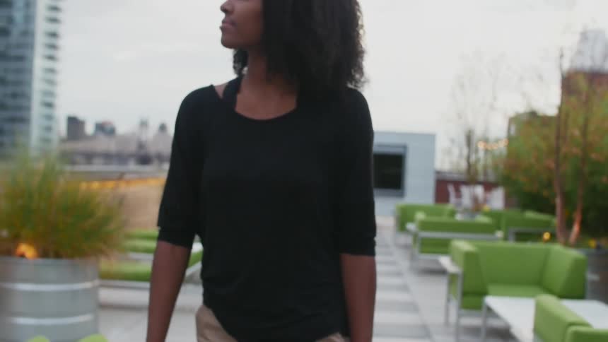 A woman walks on a rooftop