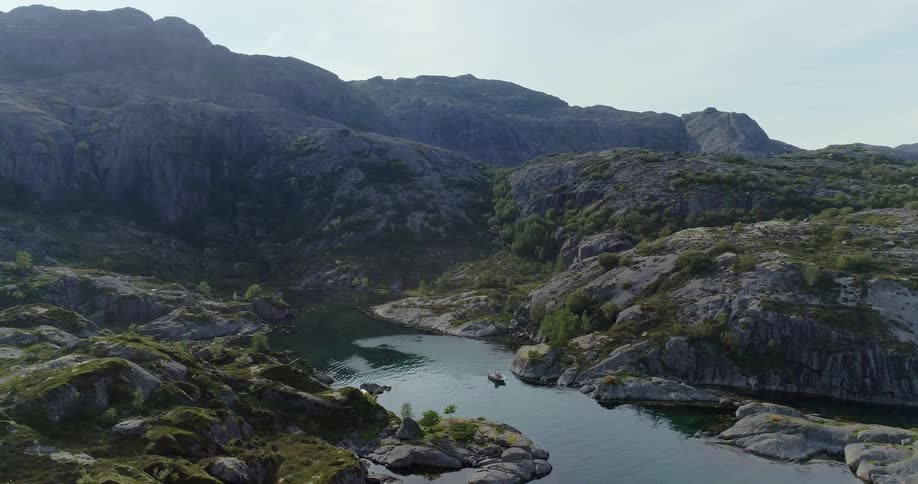 Boat floats down a river through the mountains