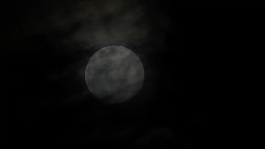 Clouds float in front of the moon
