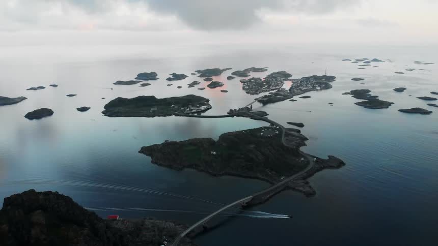 A boat travels under a bridge which connects islands