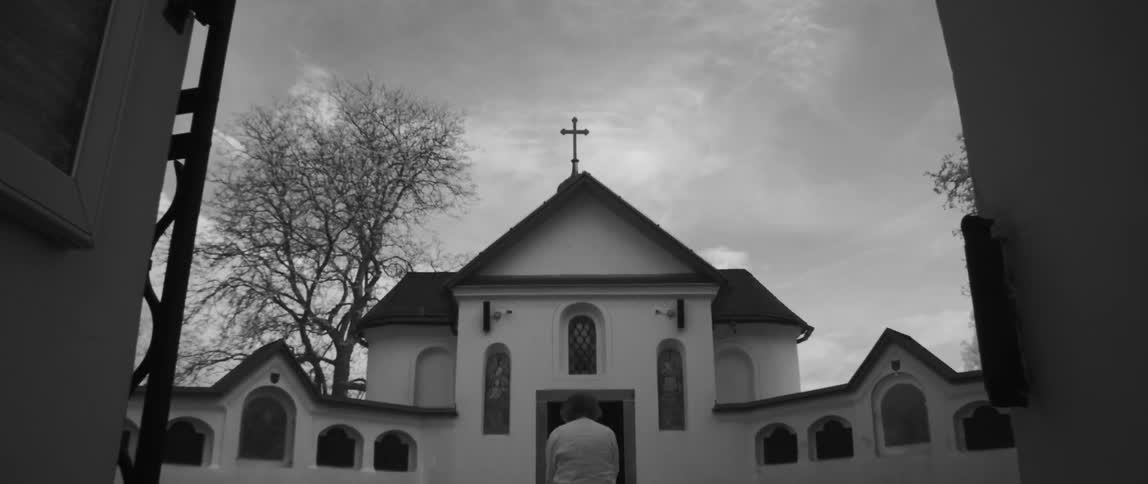 Woman sits in front of a white church