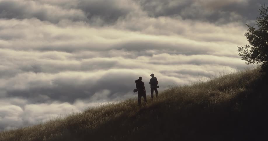 Two people are standing together on the hill