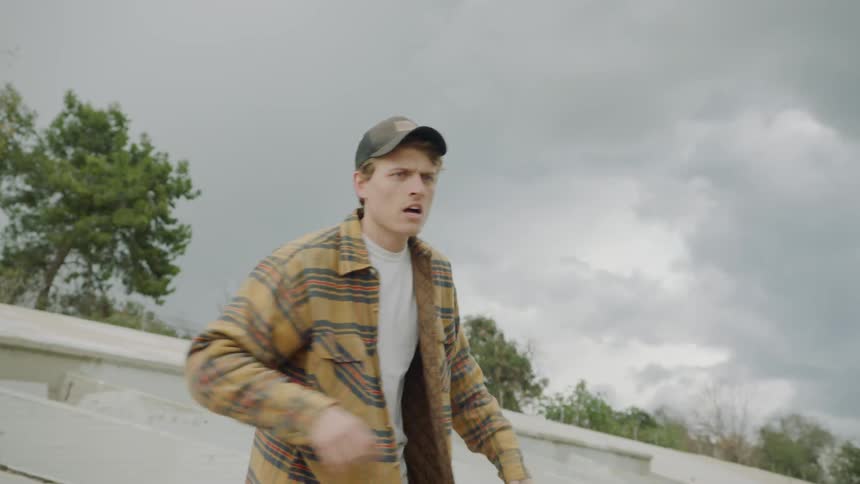 A man swings a water jug and hits a man in the head