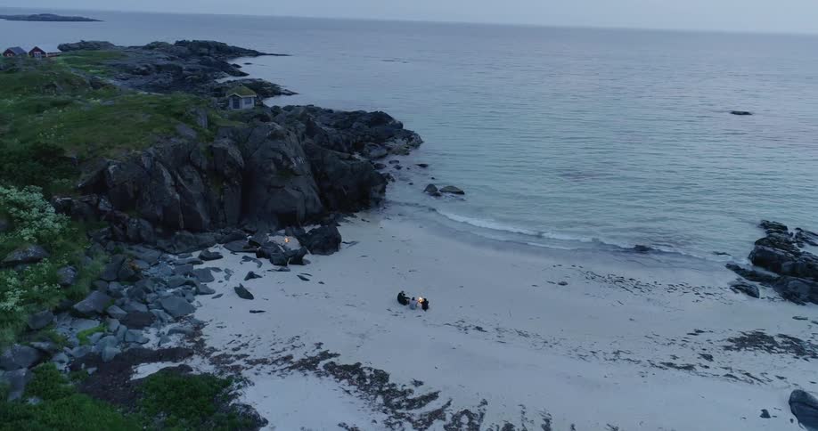 The waves slowly hit the shore where people are sitting in the sand