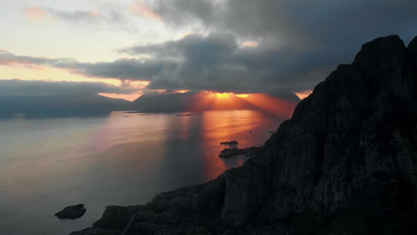 Sun sets behind the clouds over a lake