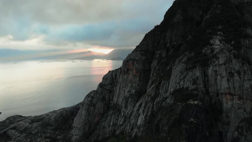 The sun sets over a coastal cliff