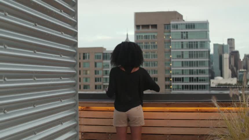 A woman is wiping ice from the ledge of her roof