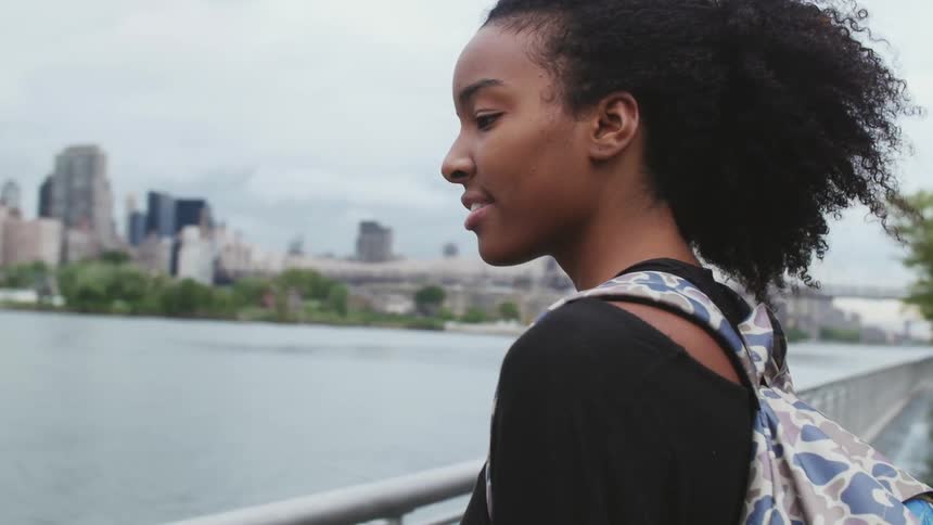 Woman walking to a railing to look at the water