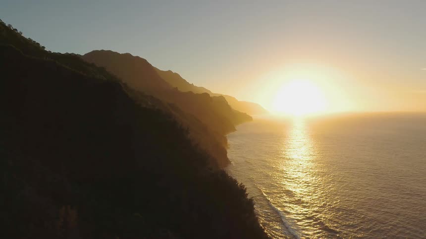 Waves roll towards shore at sunset