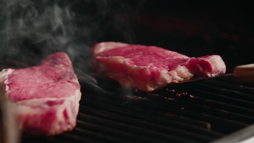 Steaks barbecuing on a grill