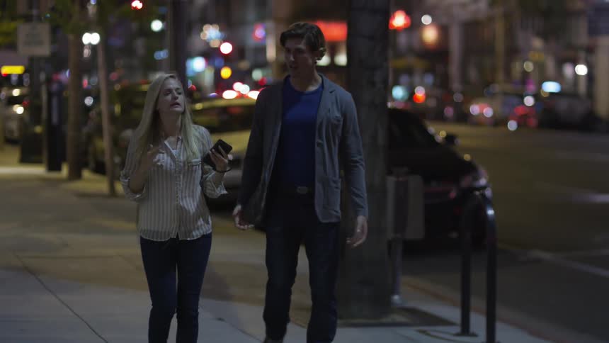 Man and woman walking down a city street