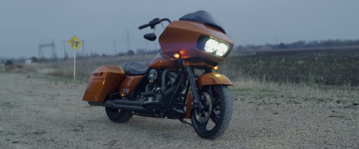 Motorcycle parked on side of highway after sunset