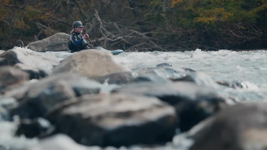 A person is rowing in the rough rapids
