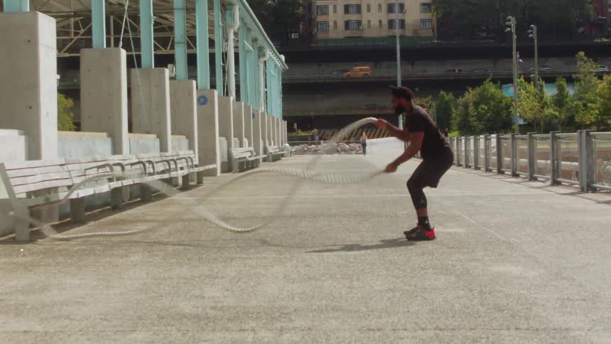 A man is pulling ropes in the park