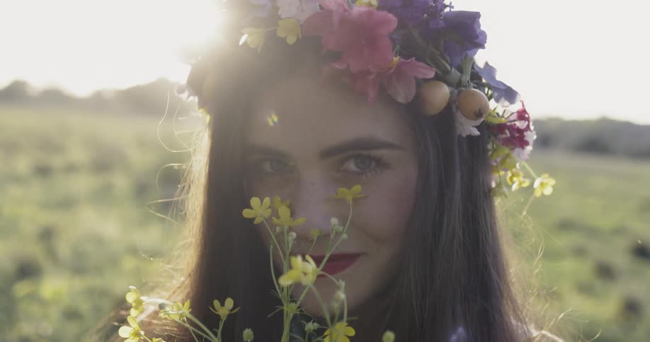 A woman holds flowers up and smiles