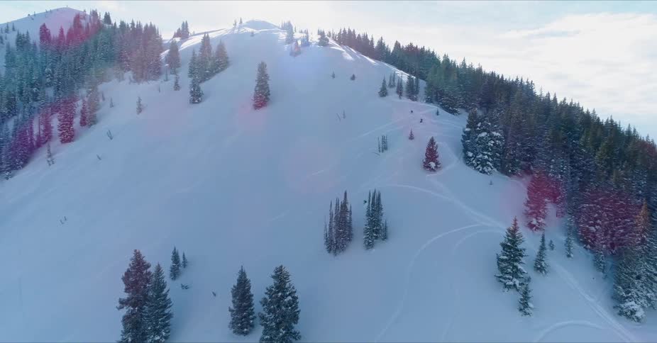 Skiers glide down a snowy mountainside