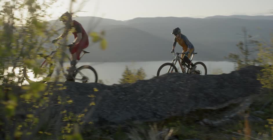 Bicyclists ride next to a lake