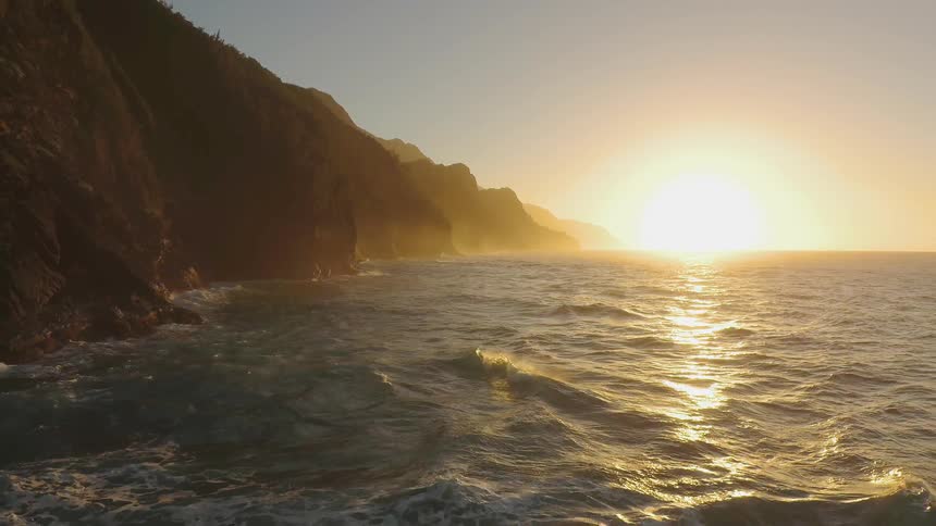 Waves are crashing ashore as the sun sets
