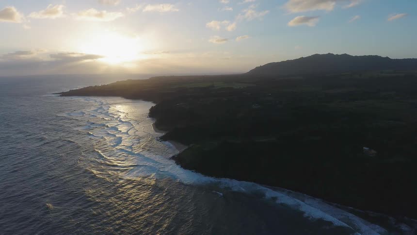Waves roll towards shore at sunset