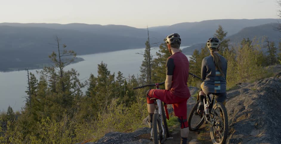Two people sit on their bikes taking in the view