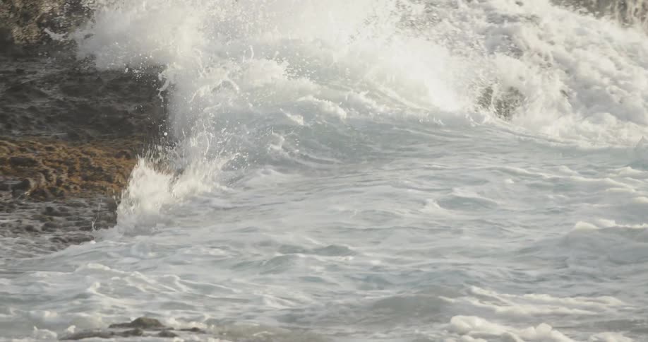 Ocean waves crash into rocks