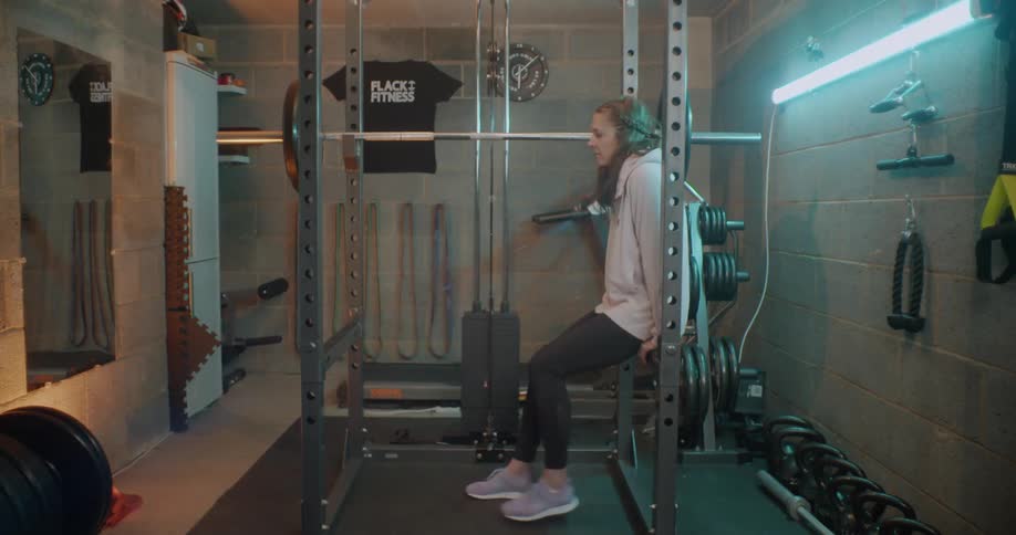 A woman is doing some stretches in the gym