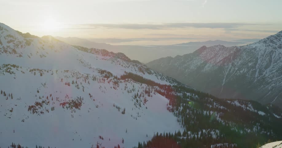 Sun shines over snow covered mountains