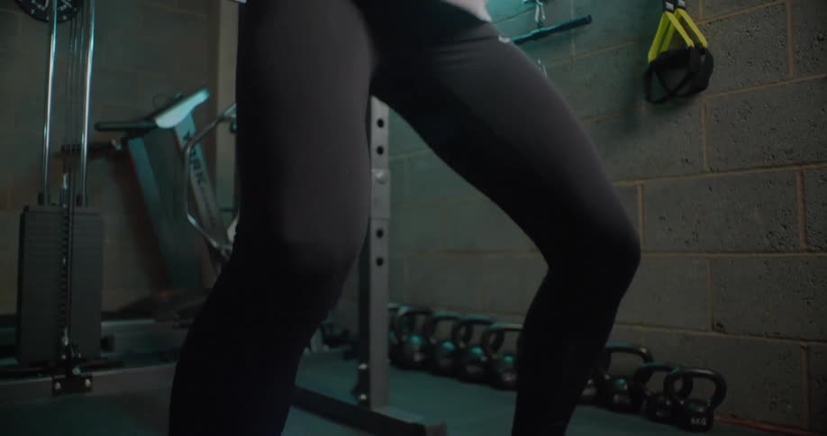 Woman does squats in a gym