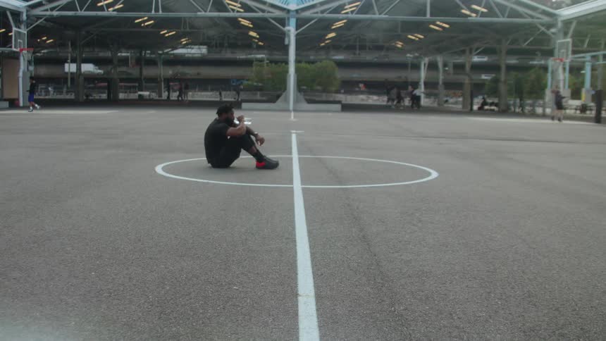 Man sits in the middle of a sport court