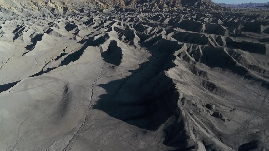 Shadows cast over a hilly rigid desert