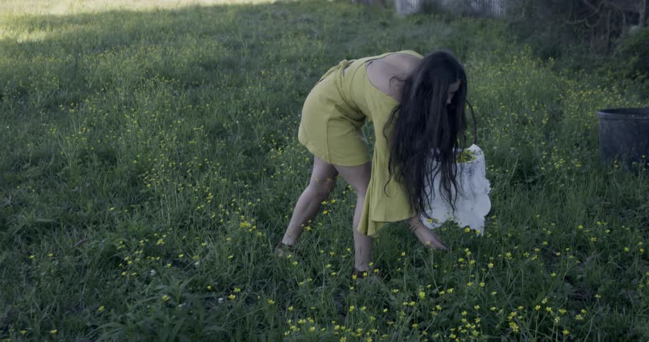 Woman carries a basket as she walks in  field