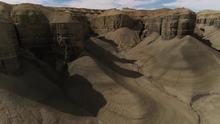 Clouds float above rock formations in a desert