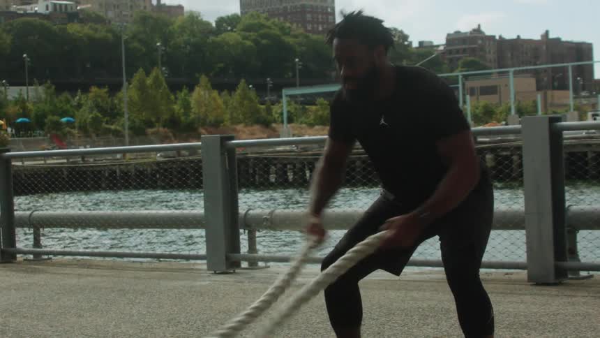 Man exercises using two ropes outside