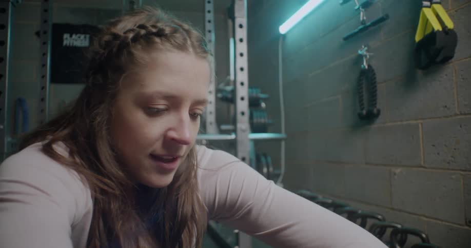 Woman exercises on a machine in a gym at night