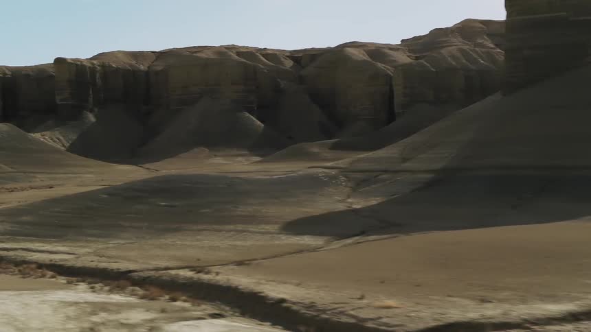 Flat hills sit under a blue sky