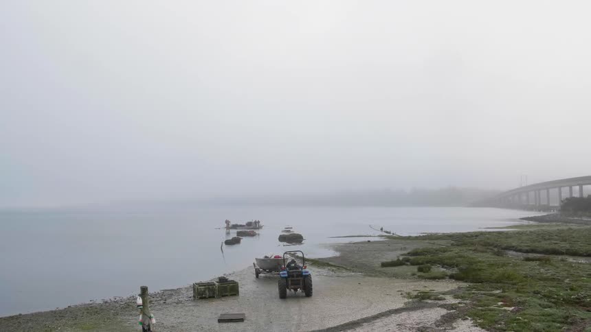 A boat on a trailer is pushed into the water