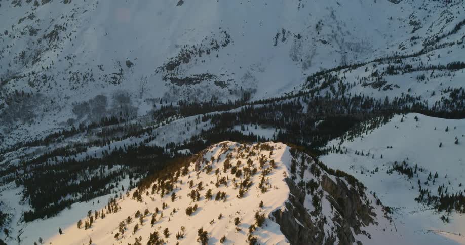 Snow covers mountains at sunset