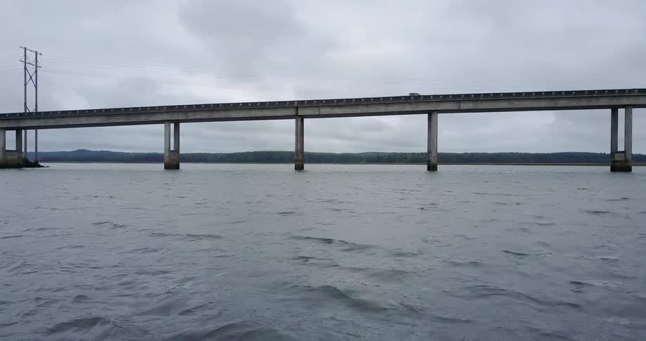 A car travels across a bridge over water
