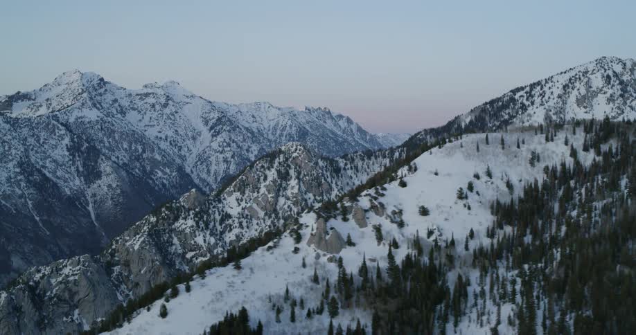 Mountain peaks, ridges and slopes covered in trees and snow