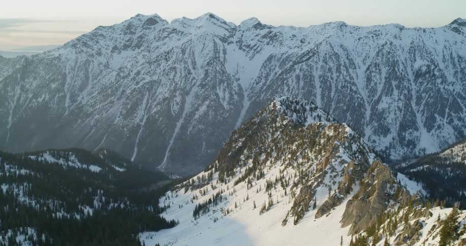 Snow covers mountain ridges at sunset